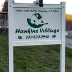 Sign and frame install, customized with solar-powered lights. Hankins Village roadside sign
